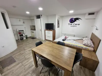 a room with a table and a bed and a desk at The Cave in Ljubljana