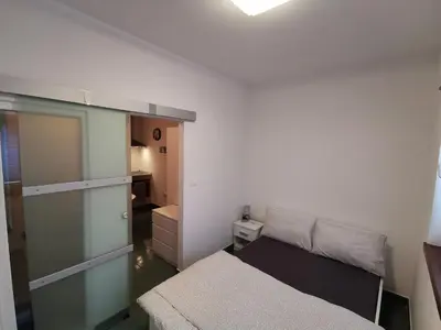 a small bedroom with a bed and a closet at Goriška Apartments in Ajdovščina