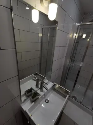 a white bathroom with a sink and a shower at Goriška Apartments in Ajdovščina