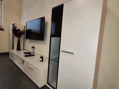 a room with a white dresser with a tv on the wall at Goriška Apartments in Ajdovščina