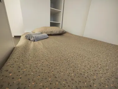 a bed with a blanket and pillows on it at Goriška Apartments in Ajdovščina