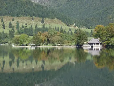a house sitting on the shore of a lake at Accommodation Destina, LAKE BOHINJ in Bohinj