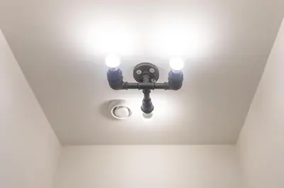a light fixture on the ceiling of a room at Stay in pub KAMERA KLUB apatment-city center in Ljubljana