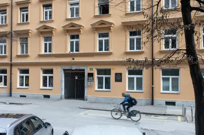 a person riding a bike in front of a building at Stay in pub KAMERA KLUB apatment-city center in Ljubljana