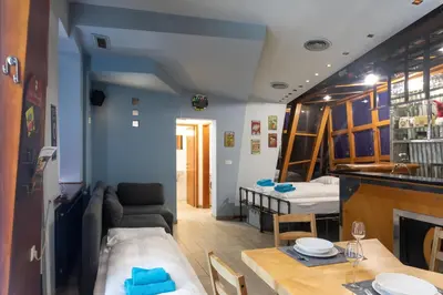 a room with a dining table and a living room at Stay in pub KAMERA KLUB apatment-city center in Ljubljana