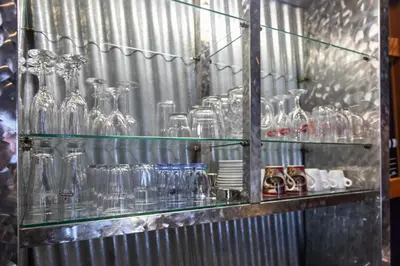 a bunch of glass bottles on a shelf at Stay in pub KAMERA KLUB apatment-city center in Ljubljana