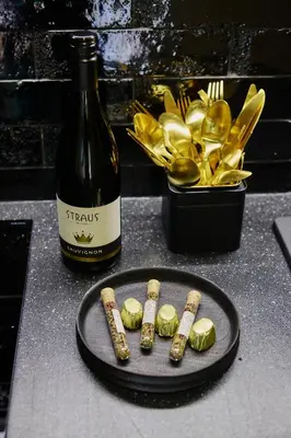 a bottle of wine and a plate of food and a bottle of champagne at Tri Vile Estate, a piece of paradise in Kozjansko in Podčetrtek