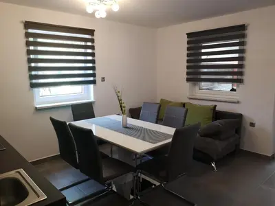 a dining room with a table and chairs and a couch at APP Vanja 6170 in Čatež ob Savi