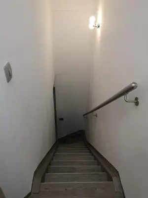a staircase with a light on the wall and a hand rail at APP Vanja 6170 in Čatež ob Savi