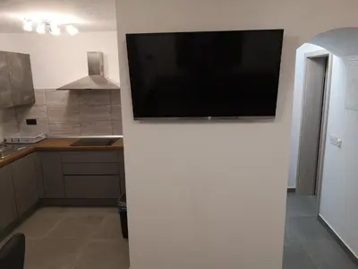 a flat screen tv on a wall in a kitchen at APP Aleksa 6168 in Čatež ob Savi