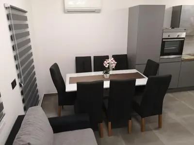 a dining room with a white table and black chairs at APP Aleksa 6168 in Čatež ob Savi