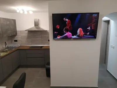 a kitchen with a flat screen tv on a wall at APP Aleksa 6168 in Čatež ob Savi