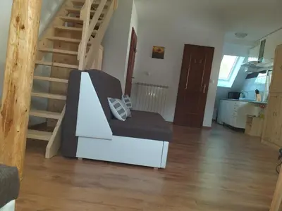 a living room with a chair and a staircase at ODAI in Bovec