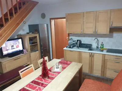 a kitchen with a table and a kitchen with a television at Apartma DA-LI SPORTS -ROGLA in Zreče