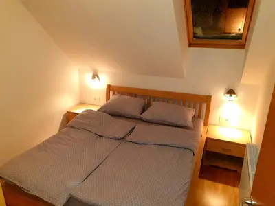 a bedroom with a bed with two lamps on it at Apartma DA-LI SPORTS -ROGLA in Zreče