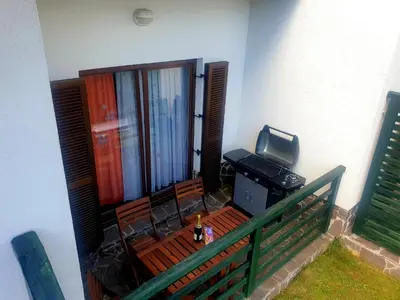 a balcony with a bench with a television and a desk at Apartma DA-LI SPORTS -ROGLA in Zreče
