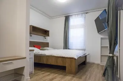 a small bedroom with a bed and a window at Jantar Apartmaji in Novo Mesto