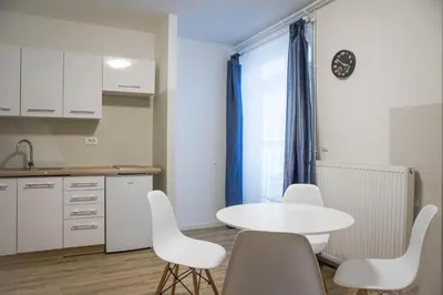 a kitchen with a white table and white chairs at Jantar Apartmaji in Novo Mesto