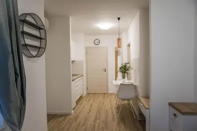 a kitchen with a table and a clock on the wall at Jantar Apartmaji in Novo Mesto