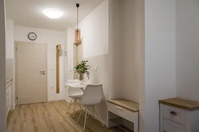 a kitchen with a table and chairs and a clock on the wall at Jantar Apartmaji in Novo Mesto