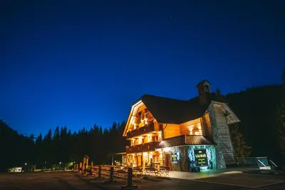 a large building with lights on at night at Guesthouse Lajnar in Zgornja Sorica