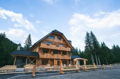 a large wooden building with a gambrel at Guesthouse Lajnar in Zgornja Sorica