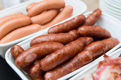 a group of sausages and hot dogs in trays at Guesthouse Lajnar in Zgornja Sorica