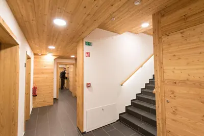 a hallway with wooden ceilings and stairs in a building at Guesthouse Lajnar in Zgornja Sorica
