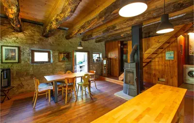 a dining room with a wooden table and a stove at Amazing Home In Tolmin With Sauna in Tolmin