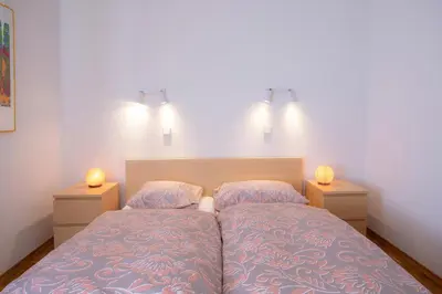 a bedroom with a bed with two lamps on it at Apartment Melody Bled in Bled