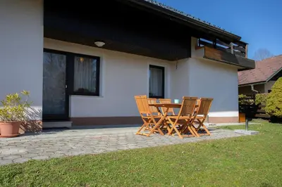 a table and chairs in front of a house at Apartment Melody Bled in Bled
