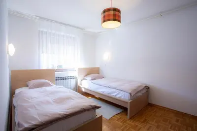 a bedroom with two beds and a window at Apartment Melody Bled in Bled
