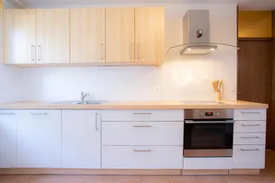 a kitchen with white cabinets and a sink and a stove at Apartment Melody Bled in Bled