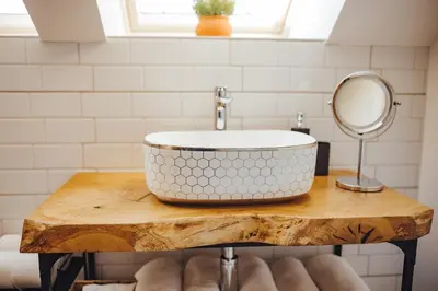 a bathroom sink on a wooden table with a mirror at Drive Caffe Apartments in Trzin