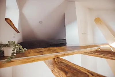 a bedroom in a tiny house with a wooden platform at Drive Caffe Apartments in Trzin
