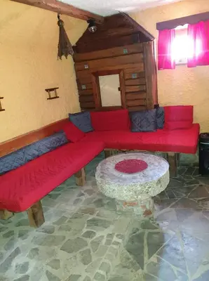 a living room with red couches and a table at Apartma Miša, Tomo Ketiš sp in Prevalje