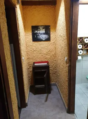 a bathroom with a small stool and a picture on the wall at Apartma Miša, Tomo Ketiš sp in Prevalje