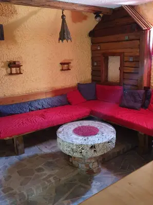 a living room with a red couch and a table at Apartma Miša, Tomo Ketiš sp in Prevalje