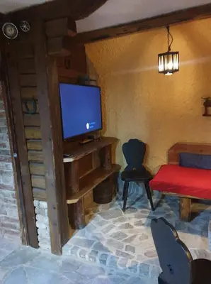 a living room with a tv and a table and a chair at Apartma Miša, Tomo Ketiš sp in Prevalje
