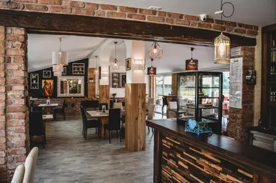 a restaurant with a dining room with tables and chairs at Ta Fabrika Restavracija,pizzerija in prenočišča in Dravograd