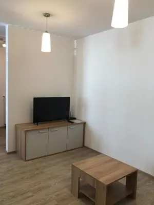 a living room with a flat screen tv and a table at Apartmaji Kramar Rateče in Kranjska Gora