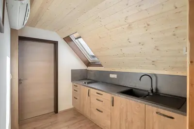 a kitchen with a sink and a wooden ceiling at Apartmaji Katja in Bohinj