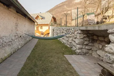 a stone wall with a hammock hanging over it at Apartmaji Katja in Bohinj
