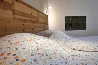 a bed with a comforter on it in a bedroom at Apartmaji Katja in Bohinj