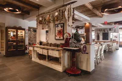 a restaurant with a counter and a bar with chairs at Hotel Grof in Vransko