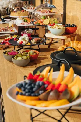 a buffet of food on a table with plates of fruit at Hotel Grof in Vransko