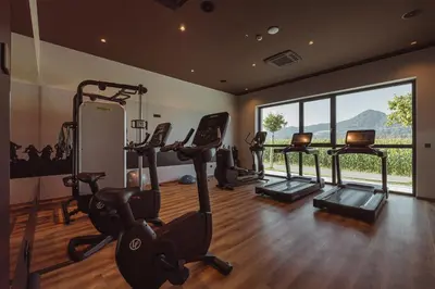 a gym with tread machines and a large window at Hotel Grof in Vransko