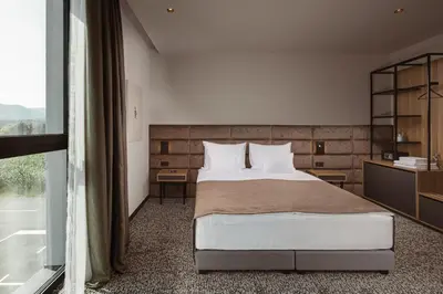 a bedroom with a bed and a large window at Hotel Grof in Vransko
