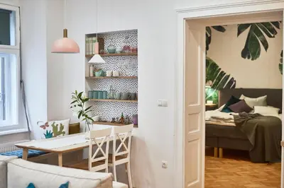 a living room with a table and a room with a bed at FERN apartments in Maribor