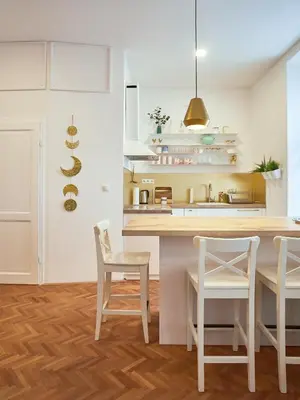 a kitchen with white cabinets and a table and chairs at FERN apartments in Maribor
